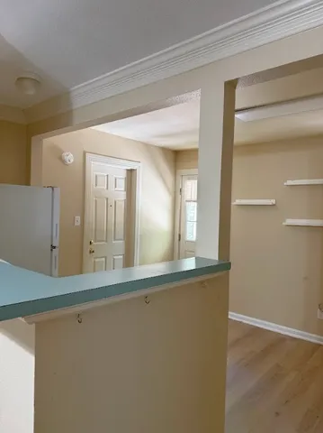a view of a hallway with wooden floor and a large mirror