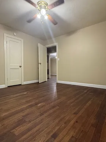 a view of a livingroom with wooden floor and a ceiling fan