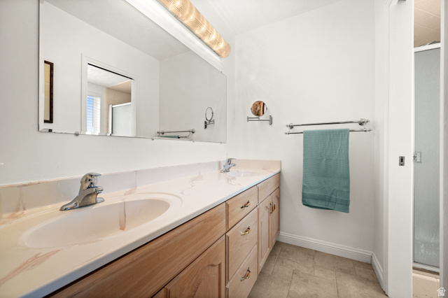 1650 Nichole Circle Sandy, UT 84093 - Photo 15 of 31 Double vanity with integrated sinks, light wood-finish cabinetry, and a large wall-mounted mirror