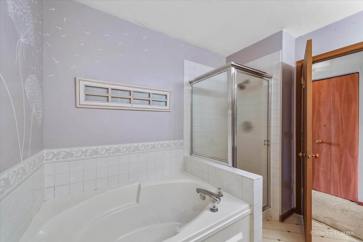 687 Bent Ridge Lane Elgin, IL 60120 - Photo 17 of 28 a bathroom with a bathtub and a shower