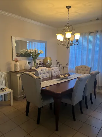 a view of a dining room with furniture a chandelier and wooden floor
