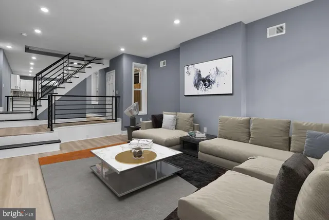 a living room with furniture and stairs