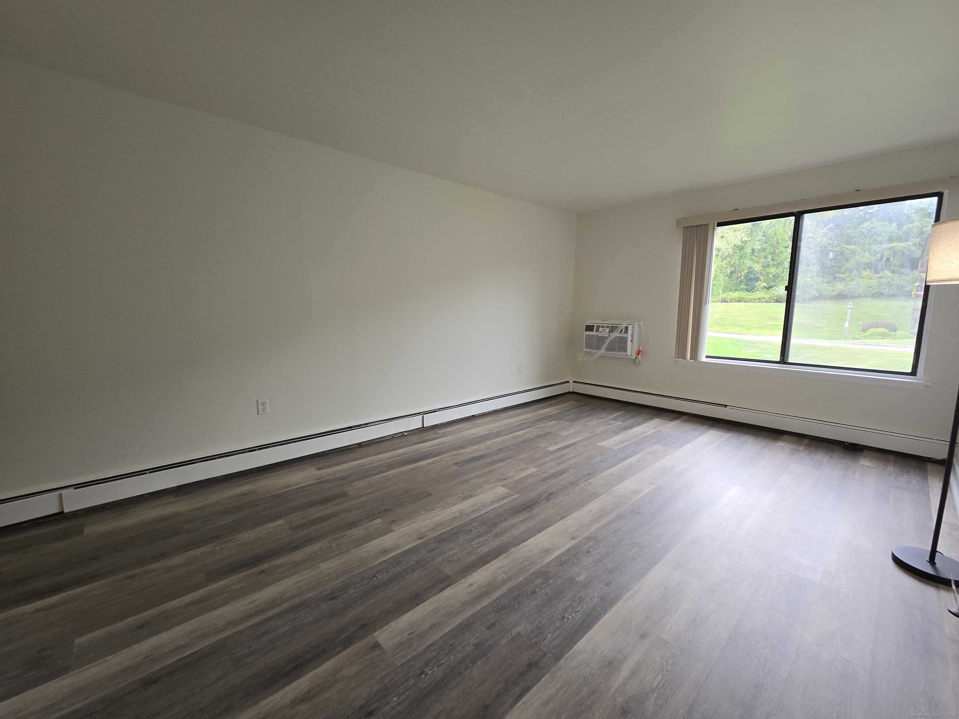 1209 Cromwell Hills Drive, Unit 1209 Cromwell, CT 06416 - Photo 17 of 27 an empty room with wooden floor and windows