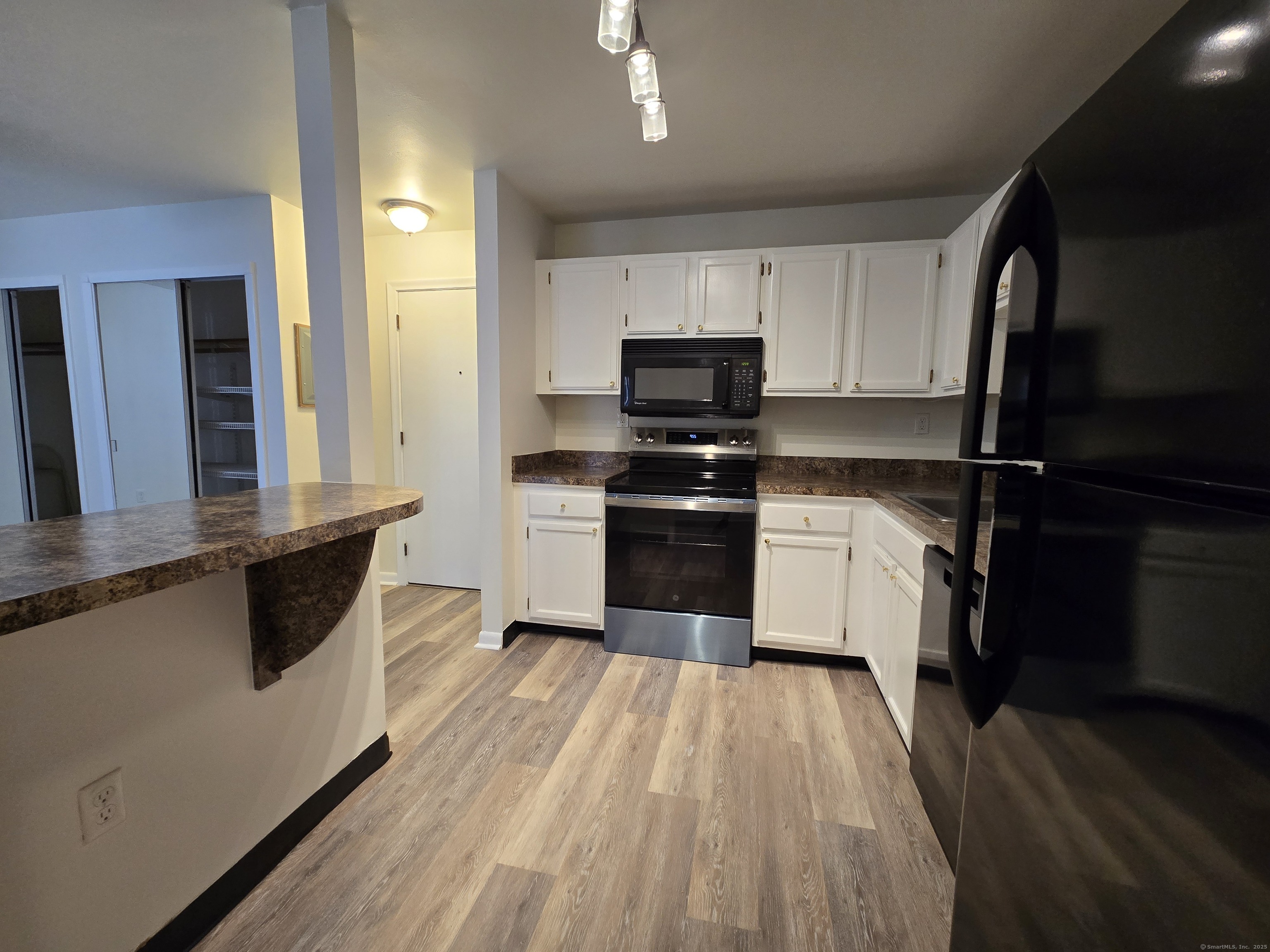 1209 Cromwell Hills Drive, Unit 1209 Cromwell, CT 06416 - Photo 6 of 27 a kitchen with kitchen island granite countertop a sink appliances cabinets and a counter top space
