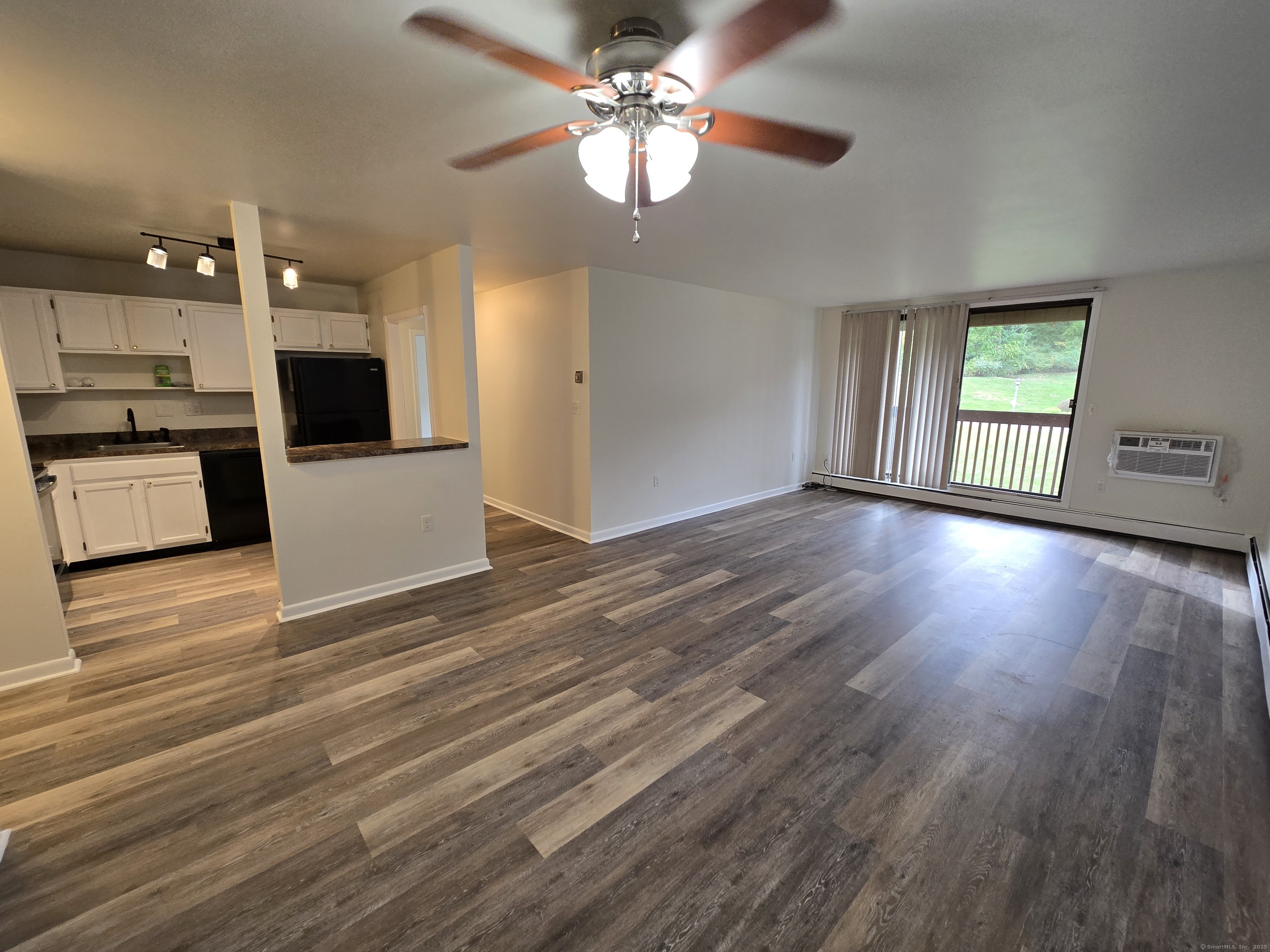 1209 Cromwell Hills Drive, Unit 1209 Cromwell, CT 06416 - Photo 8 of 27 a view of an empty room and kitchen with wooden floor