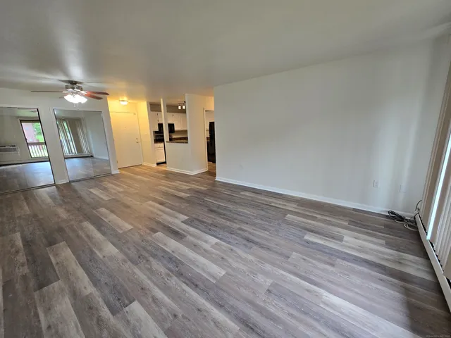 a view of empty room with wooden floor