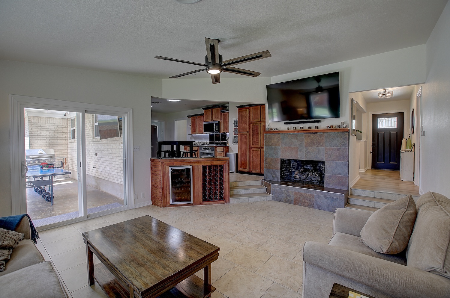 1902 East 18th Street Georgetown, TX 78626 - Photo 17 of 40 Family room with a ceiling fan, a cozy gas fireplace with gas logs, and light tile patterned floors, and beverage cooler