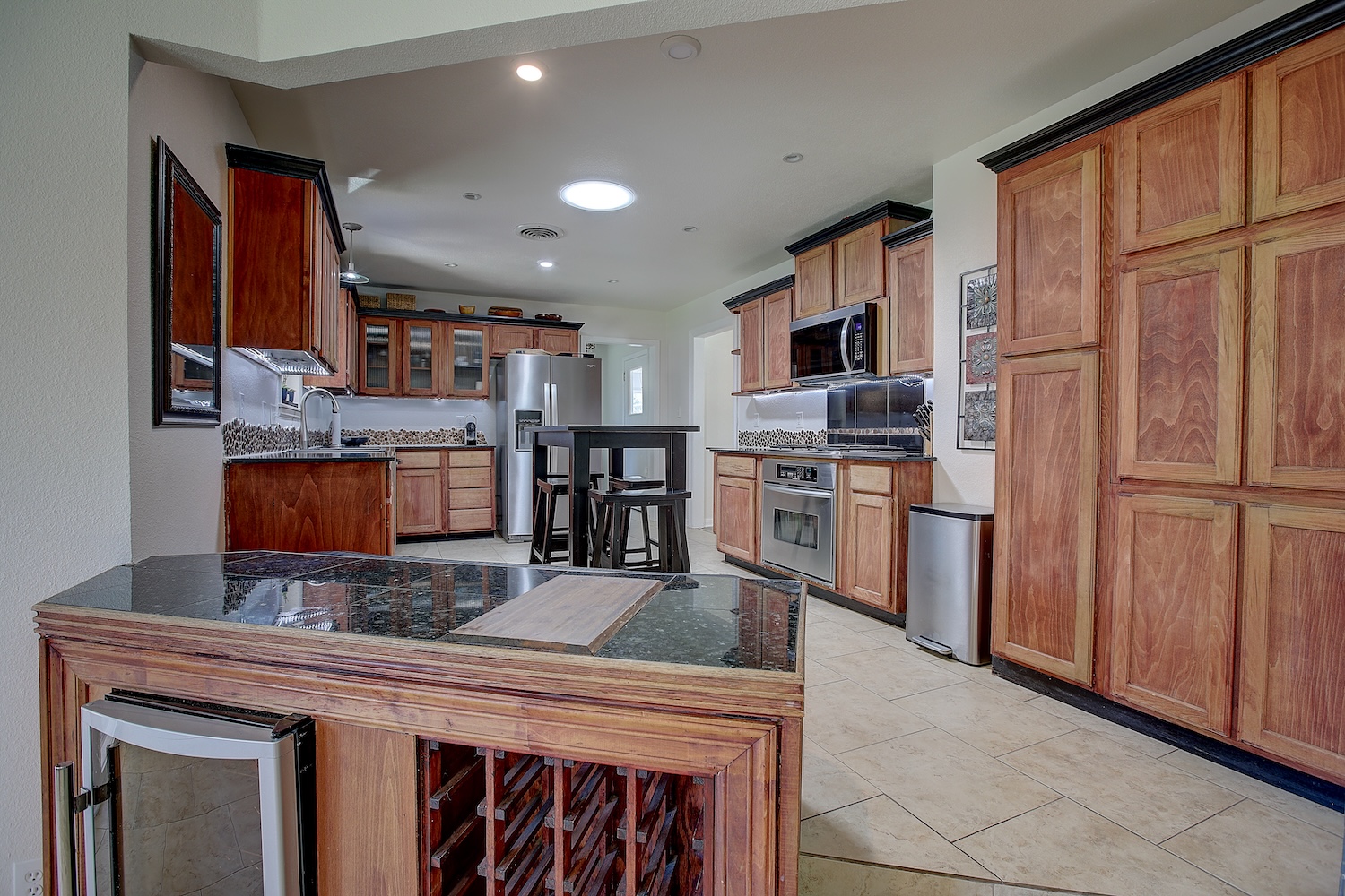 1902 East 18th Street Georgetown, TX 78626 - Photo 18 of 40 Kitchen with wood finish cabinetry, stainless steel appliances, light tile patterned flooring, recessed lighting, and glass insert cabinets