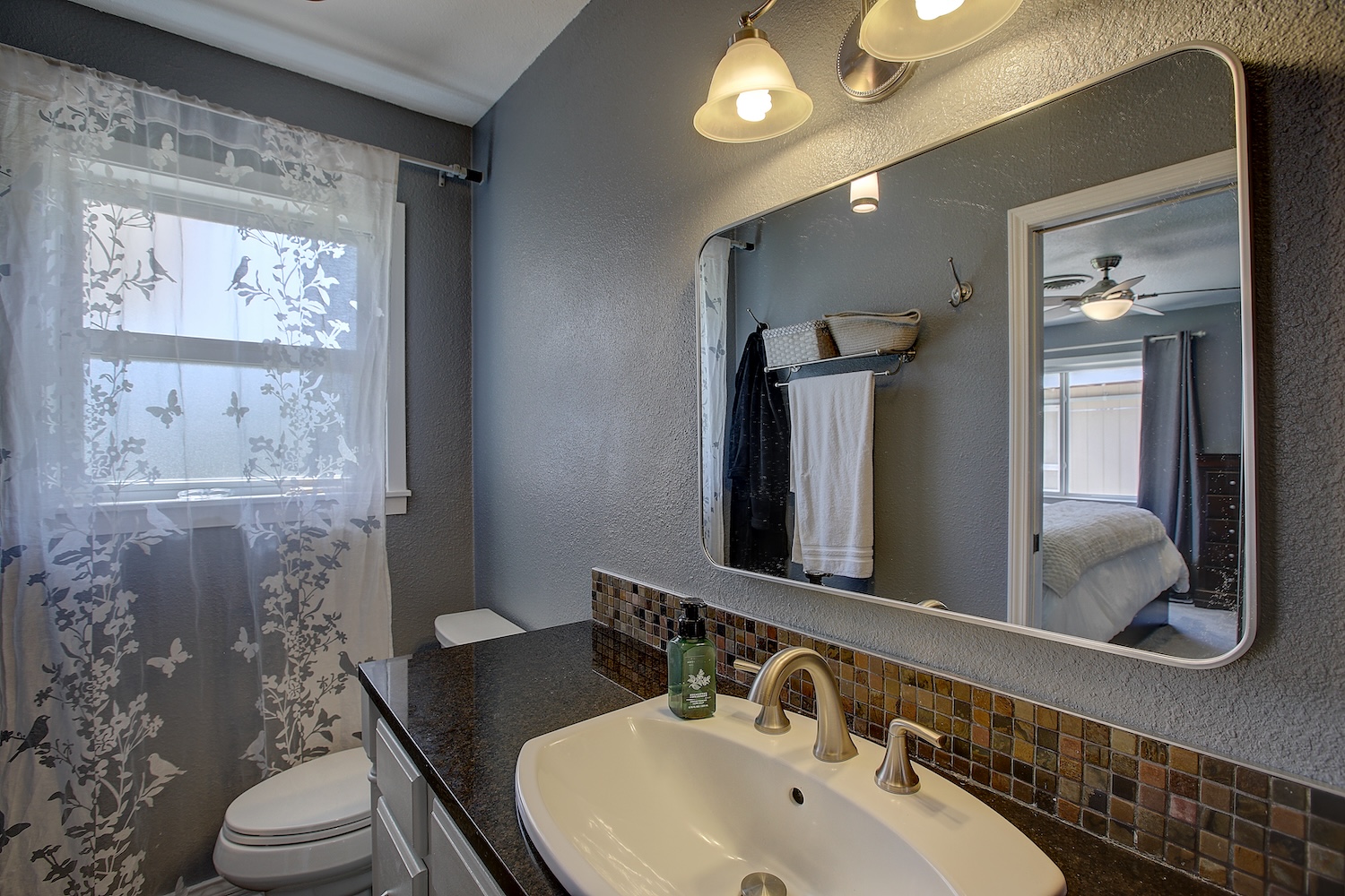 1902 East 18th Street Georgetown, TX 78626 - Photo 25 of 40 Ensuite bathroom featuring a textured wall, vanity, a shower with shower curtain, ceiling fan, and decorative backsplash