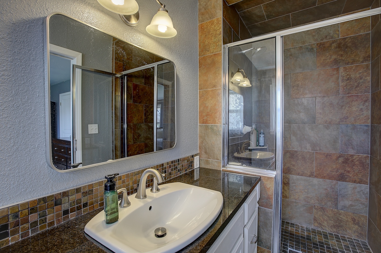 1902 East 18th Street Georgetown, TX 78626 - Photo 26 of 40 Bathroom featuring a textured wall, a stall shower, vanity, and tasteful backsplash