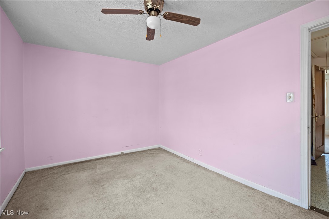 6927 North Wildacre Road Curtice, OH 43412 - Photo 33 of 44 Spare room featuring light carpet, a textured ceiling, attic access, and a ceiling fan