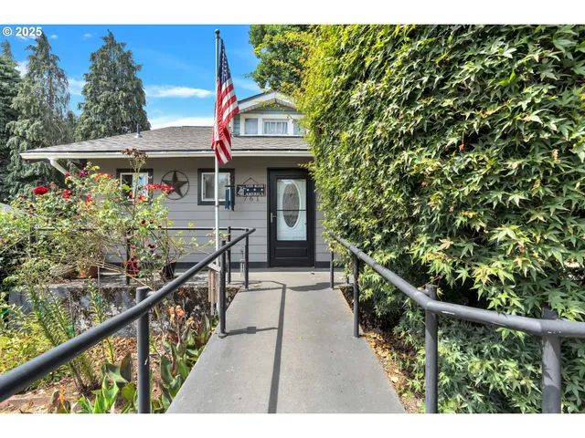 a view of a house with a small yard and wooden fence