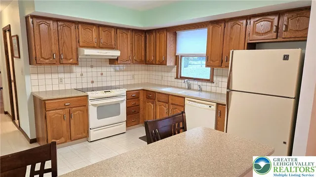 a kitchen with kitchen island a stove a refrigerator and a sink with wooden cabinets