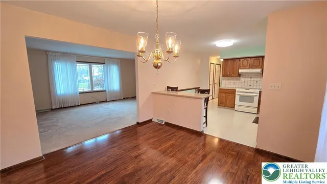a view of a kitchen with a stove wooden floor and a kitchen space