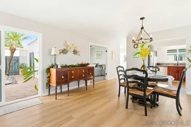 a view of a dining room and livingroom with furniture wooden floor a chandelier