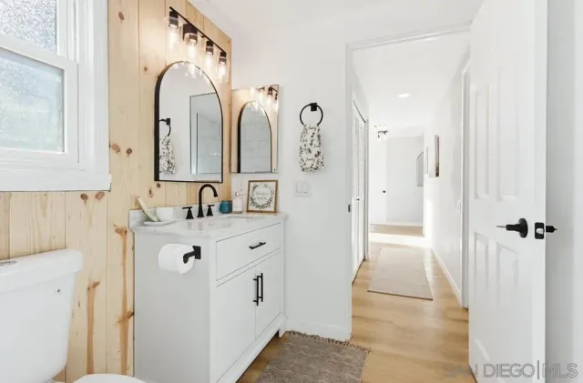 a view of a hallway with a livingroom and a bathroom