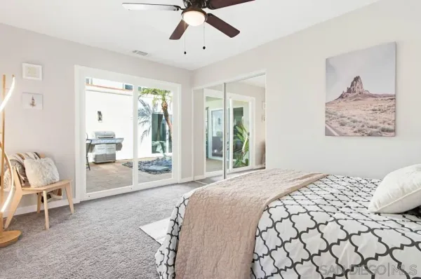 a bedroom with a bed and dresser with wooden floor