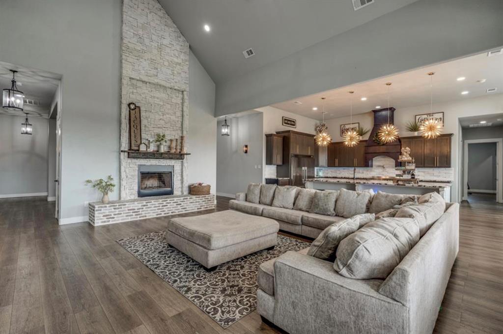 997 Ovilla Road Waxahachie, TX 75167 - Photo 31 of 32 Vaulted ceiling living area featuring a stacked stone fireplace with a wood mantle, wood-finish flooring, and recessed lighting
