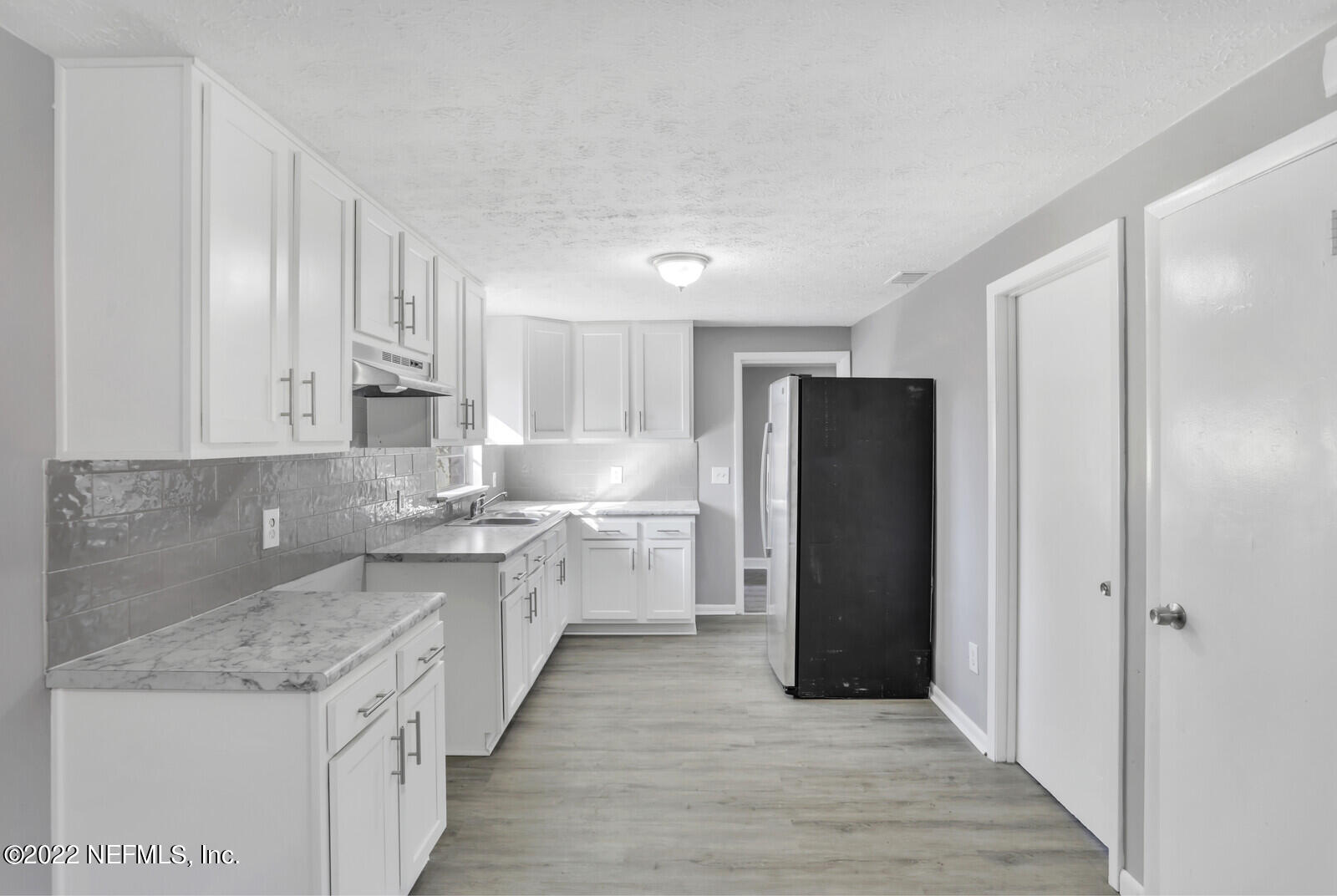 4444 Crossbow Road Jacksonville, FL 32208 - Photo 5 of 15 a kitchen with a sink and refrigerator