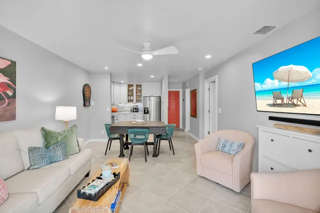 a living room with furniture and a dining table with kitchen view