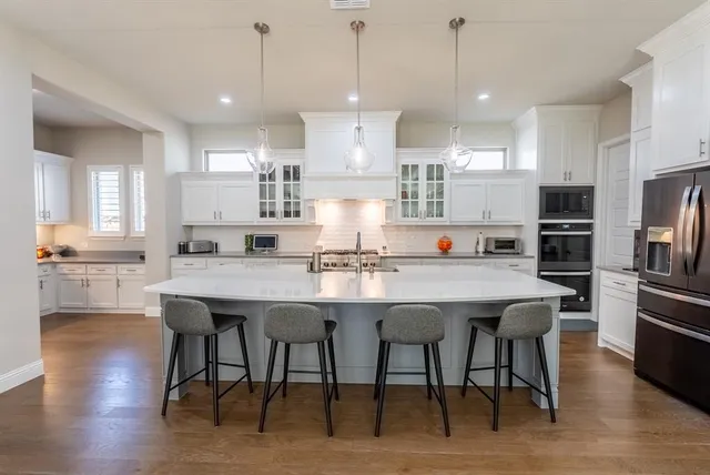a kitchen with kitchen island granite countertop a sink a center island and cabinets
