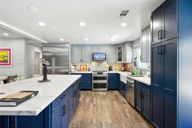 a kitchen with kitchen island granite countertop lots of counter top space and refrigerator