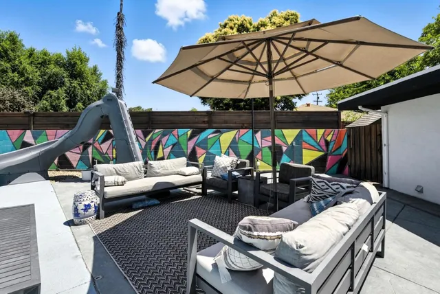 a view of a patio with table and chairs with wooden floor and fence