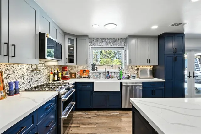 a kitchen with kitchen island granite countertop a sink stove and cabinets