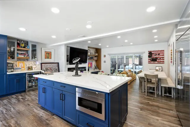 a kitchen with stainless steel appliances granite countertop a table chairs refrigerator and cabinets
