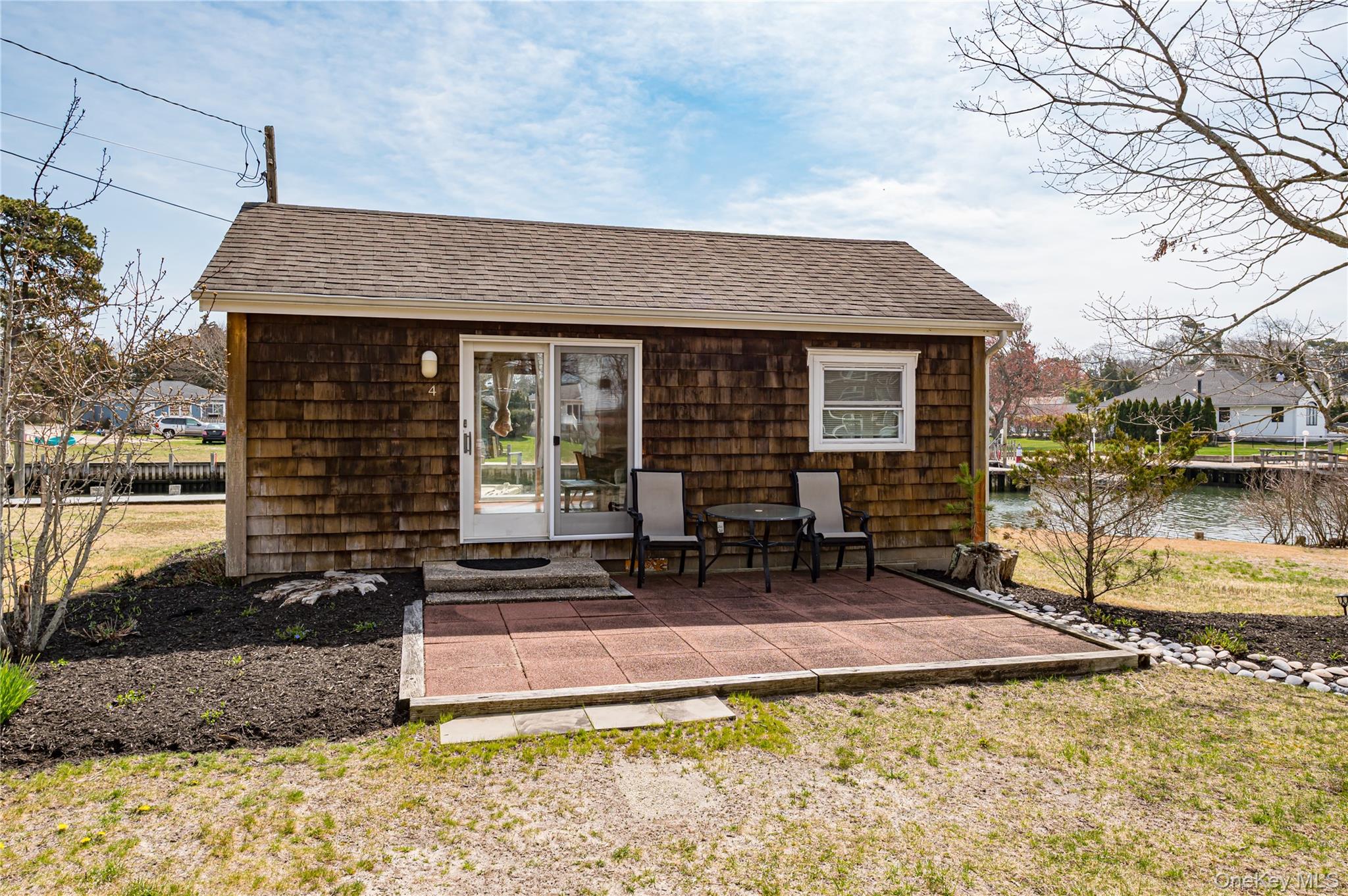 18 Shinnecock Road, Unit 4 Hampton Bays, NY 11946 - Photo 1 of 7 a view of a house with backyard porch and sitting area