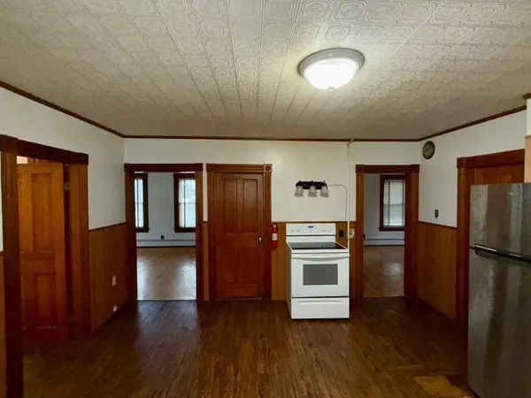 a kitchen with stainless steel appliances granite countertop a refrigerator a stove and a wooden floors