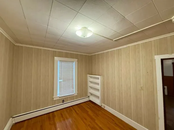 a view of an empty room with closet and a window