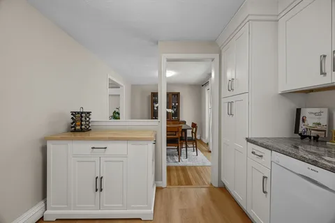 a kitchen with white cabinets and sink