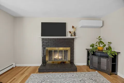 a living room with a fireplace and wooden floor