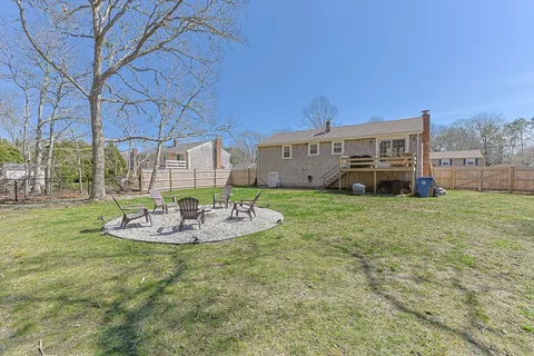 a view of a house with a big yard and large trees