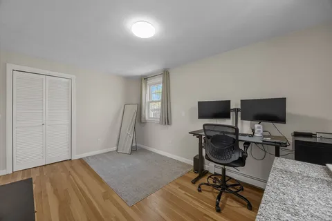 a view of a workspace with furniture and a window