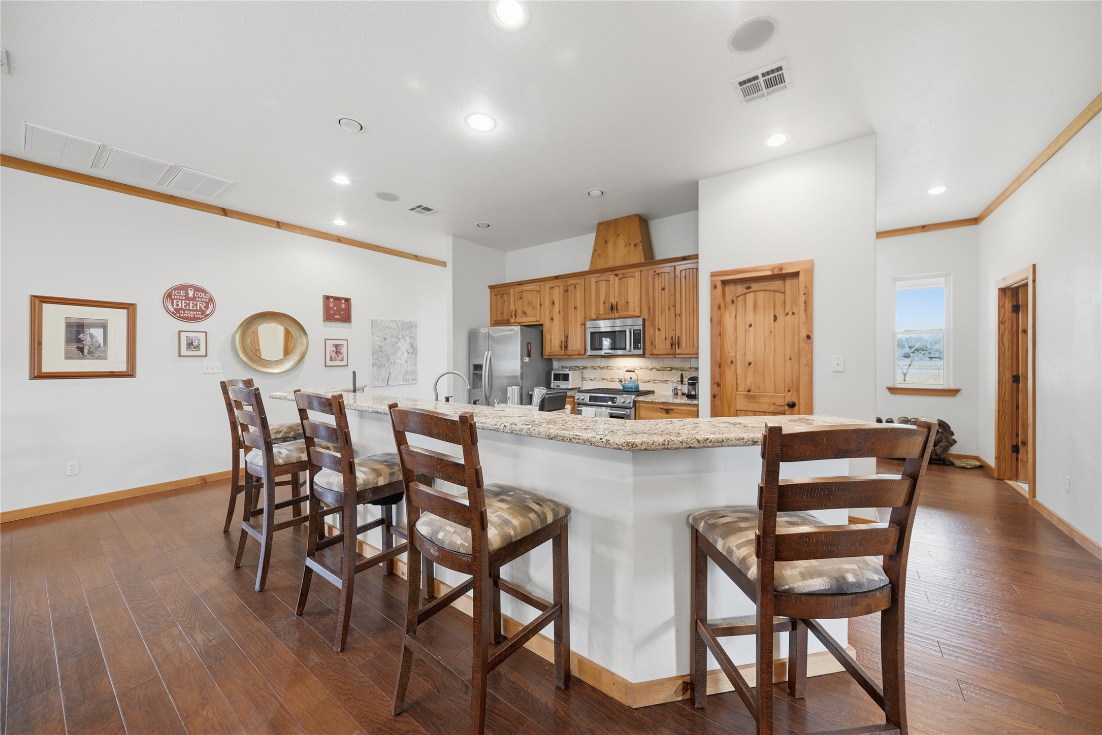 12218 Frantz Road Cat Spring, TX 78933 - Photo 7 of 25 a kitchen with stainless steel appliances a dining table chairs and wooden floor