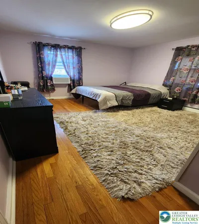 a living room with a bed and dresser