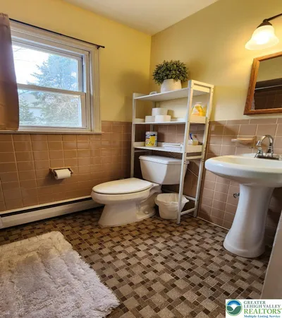a bathroom with a toilet sink and mirror