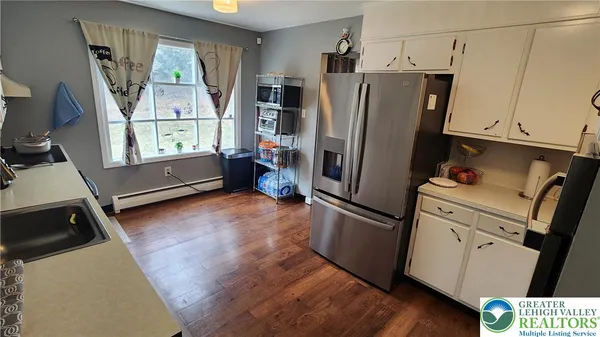 a kitchen with stainless steel appliances a refrigerator sink and wooden floor