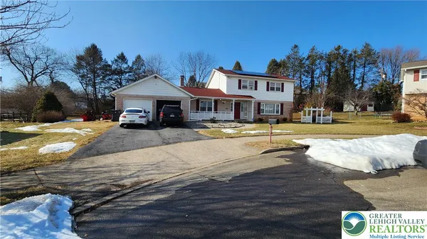 a view of a white house with a swimming pool and a yard