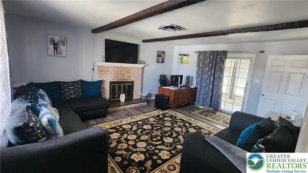 a living room with furniture a flat screen tv and a fireplace