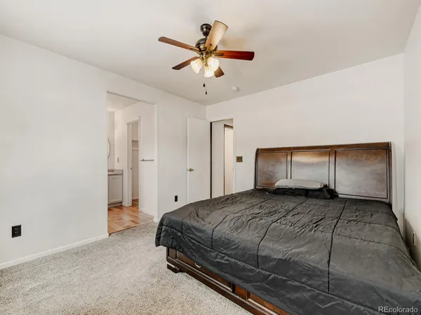 a spacious bedroom with a bed and a ceiling fan