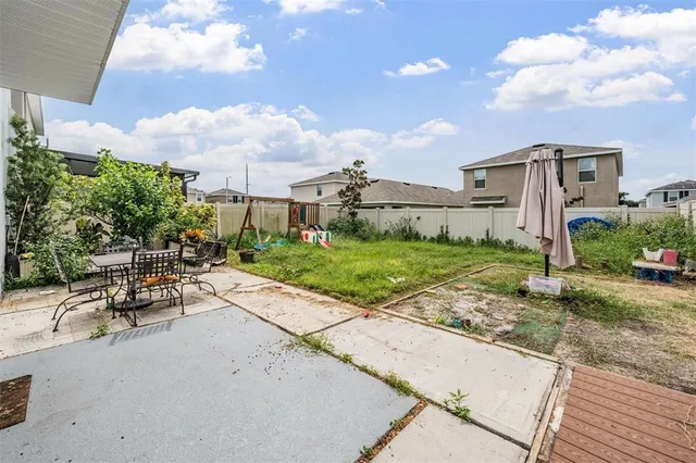a view of a patio with a table and chairs under an umbrella