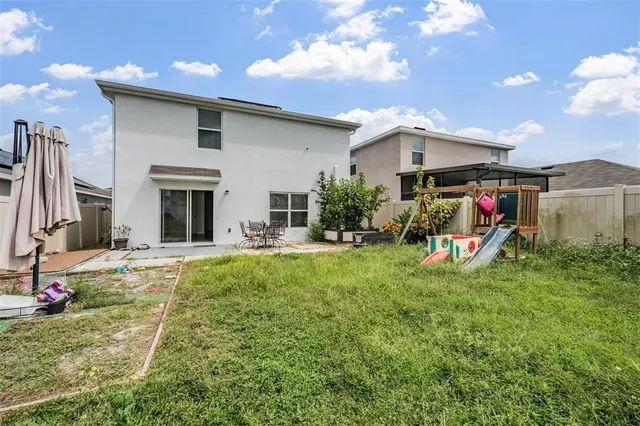 a view of a house with backyard and sitting area