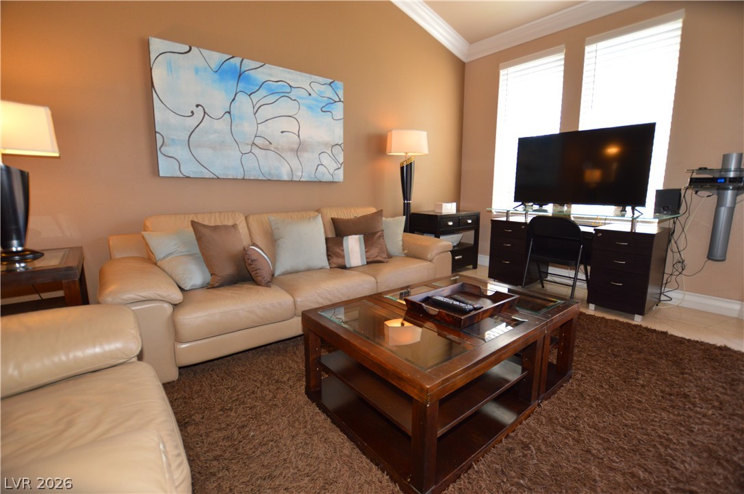 220 East Flamingo Road, Unit 327 Las Vegas, NV 89169 - Photo 10 of 13 Natural light illuminates this living space, featuring high ceilings and warm flooring for everyday comfort.