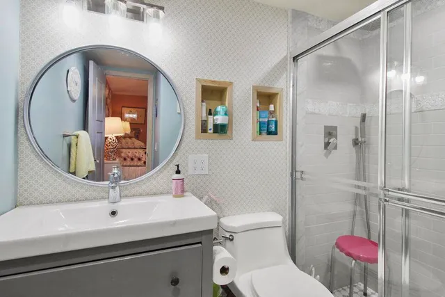 a bathroom with a toilet sink and mirror