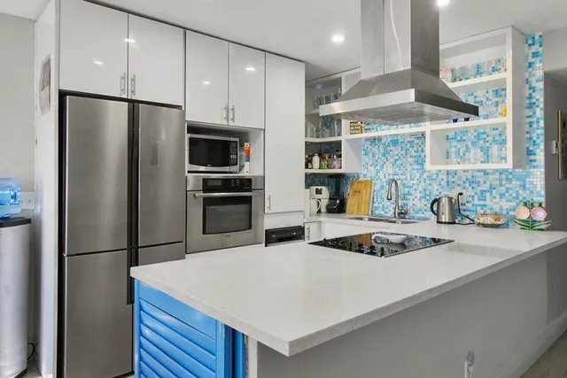 a kitchen with stainless steel appliances granite countertop a refrigerator a sink and a stove