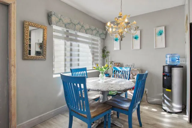 a dining room with furniture potted plants and wooden floor