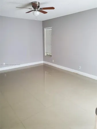a view of an empty room with a ceiling fan